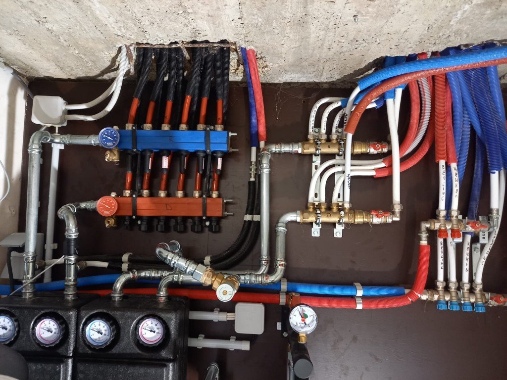 Collecteurs et tuyauteries d'une installation de chauffage avec vannes et instruments de mesure
